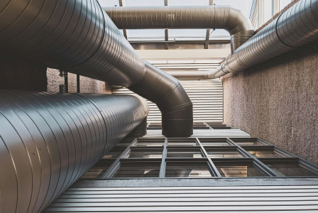 The image depicts large ventilation ducts integrated within a modern building.