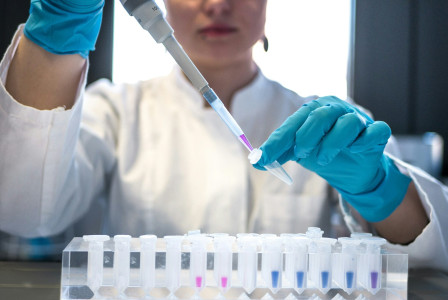 The photo presents a scientist working with laboratory samples.