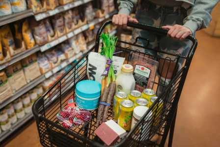 The photo presents a shopping cart filled with groceries.