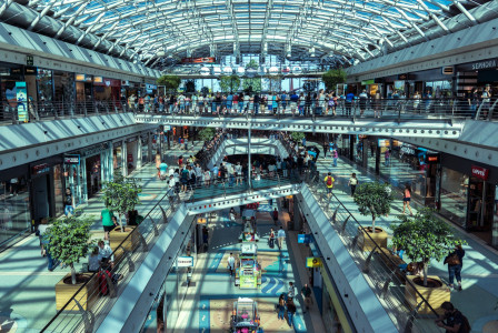 The photo presents a busy shopping mall with many people.