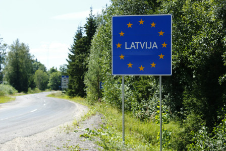The photo presents a road sign marking the border of Latvia and the European Union.