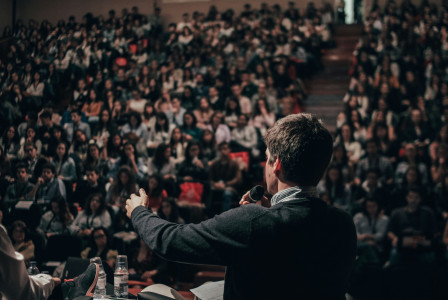 Man speaking in front of crowd.