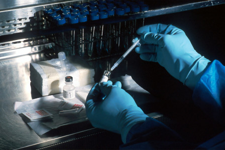 The photo presents a researcher handling laboratory samples.