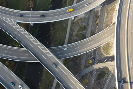 The image shows an aerial view of a ring road interchange, featuring interconnected roadways designed to facilitate traffic flow across the transport network.