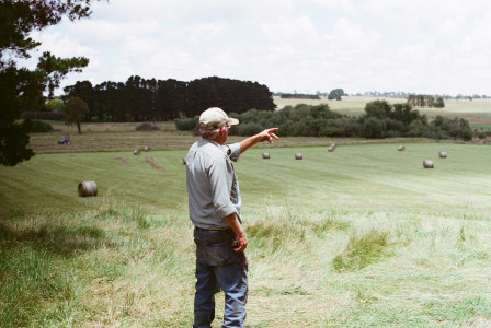 The photo presents a farmer standing in a field.