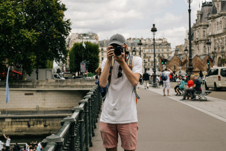 The photo presents a tourist taking a photo in Paris.