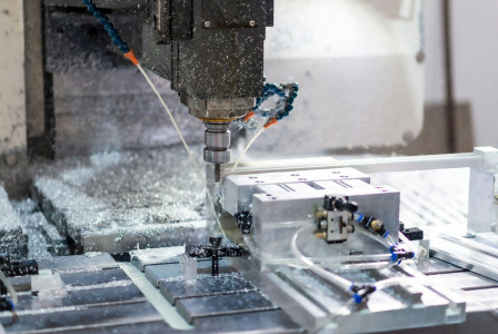 The photo presents a machine cutting metal.