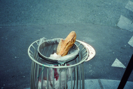 The photo presents baguettes discarded in a street rubbish bin.