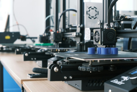 The photo presents several 3D printers.