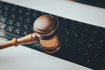 A wooden gaven sitting on top of a computer keyboard.
