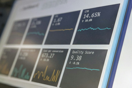 The photo presents data charts and statistics on a screen.