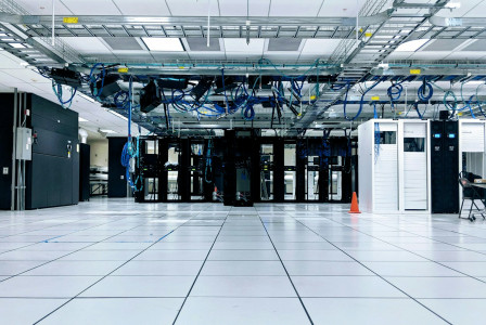 The photo presents a data centre with server racks.