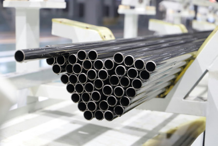 The picture describes a stack of metal pipes in an industrial manufacturing facility.