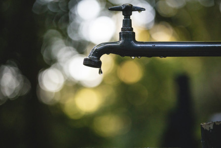 The photo presents a dripping water tap.