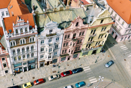 This picture shows an aerial view of colourful historic buildings lining a city street in the Czech Republic.