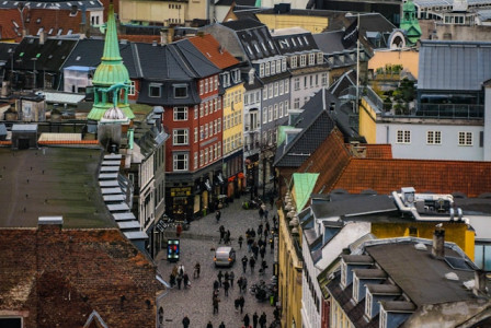 An illustrative photo of people walking along a pathway between buildings