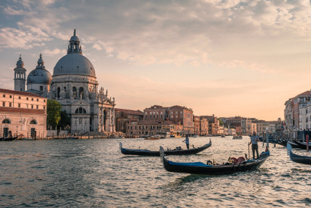 An illustrative photo of gondolas navigating a canal in Venice, Italy