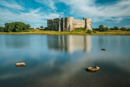 An illustrative photo of a serene body of water stretching out, reflecting the surrounding landscape