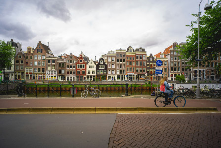Photo by Unsplash An illustrative photo of a cyclist passing dutch houses