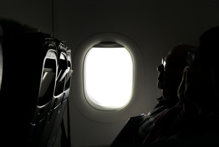 An illustrative photo of two person sitting inside of airplane.