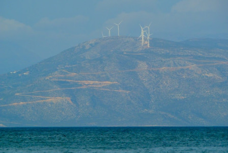 An illustrative photo of a white sailboat gliding on the sea near a mountain