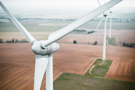 An illustrative photo of three windmills in the field