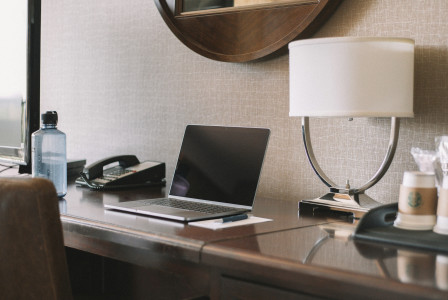 An illustrative photo of a turned off laptop computer on desk beside lamp
