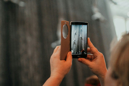 An illustrative photo of a woman taking a picture with her cell phone