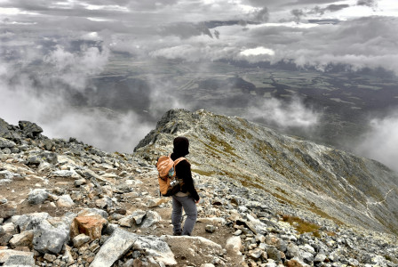 An illustrative photo of a person with a backpack on a rocky mountain,