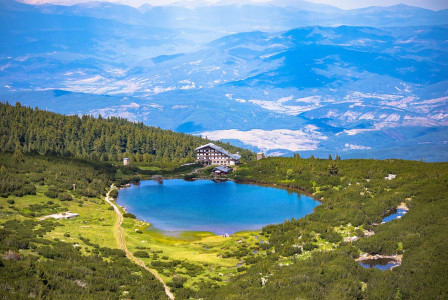 An illustrative photo of a large a mountain lake with a hotel nearby