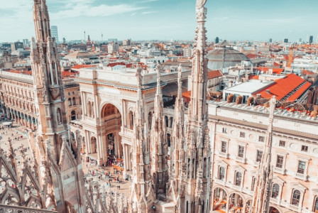 An illustrative photo of people walking on a street near buildings during daytime