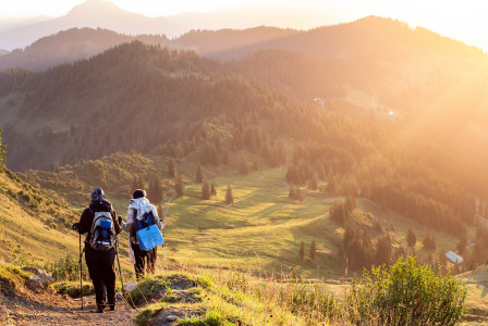 An illustrative photo of two people hiking in the mountains
