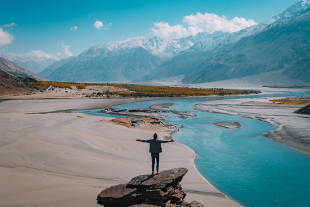 An illustrative photo of a person standing on a rock.