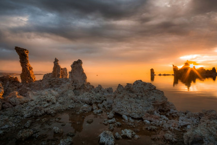 An illustrative photo of rock formations near sea during sunset
