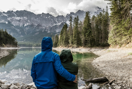 An illustrative photo of a couple standing near body of water.