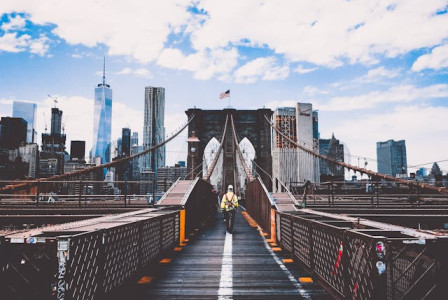 An illustrative photo of a man strolling across a bridge, enveloped in the serene ambiance of a foggy morning