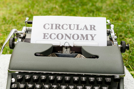 An illustrative photo of a typewriter with a sheet of paper that has the words “circular economy” typed on it