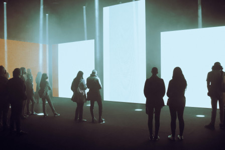 An illustrative photo of people in front of screens in a museum