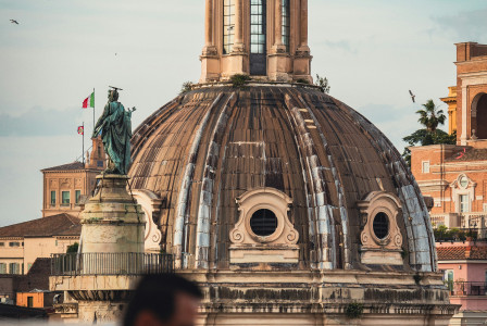 An illustrative photo of a man standing on top of a roof next to a tall building