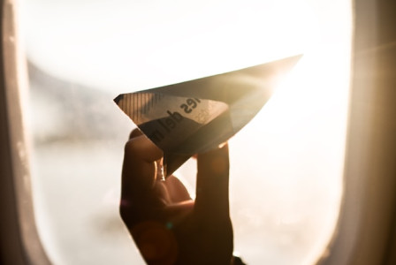 An illustrative photo of a person holding a paper plane