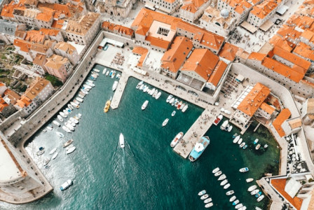 Photo by Unsplash An illustrative photo of a coastal town with terracotta-roofed buildings and a marina