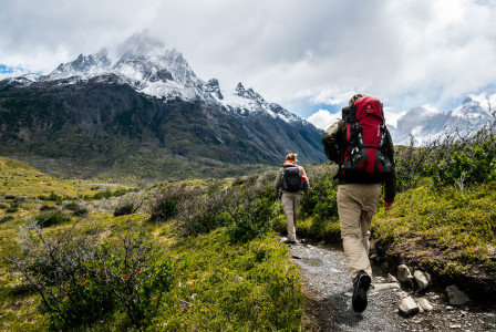 An illustrative photo of two people walking towards a mountain