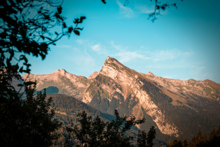 An illustrative photo of a mountain peak with blue sky