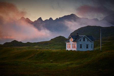 An illustrative photo of a white and gray house near mountain.