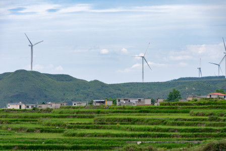 An illustrative photo of wind turbines in the mountains