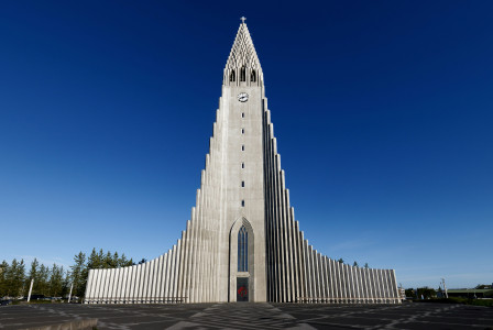 An illustrative photo of a white concrete building under blue sky during daytime