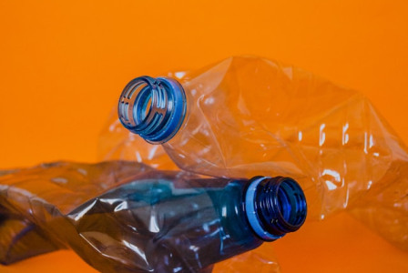 An illustrative photo of a plastic bottles lie on an orange surface