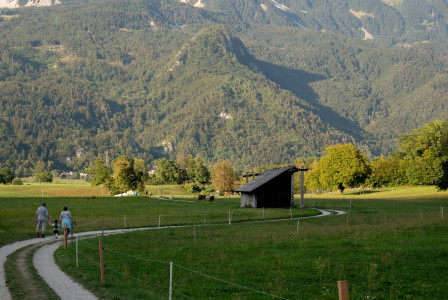 An illustrative photo of people walking on a path in a grassy field.