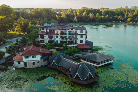 An illustrative photo of an aerial view of a resort with a lake in the foreground.