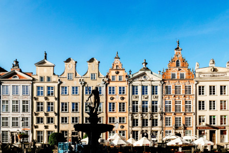 An illustrative photo of a statue of person in front of brown buildings